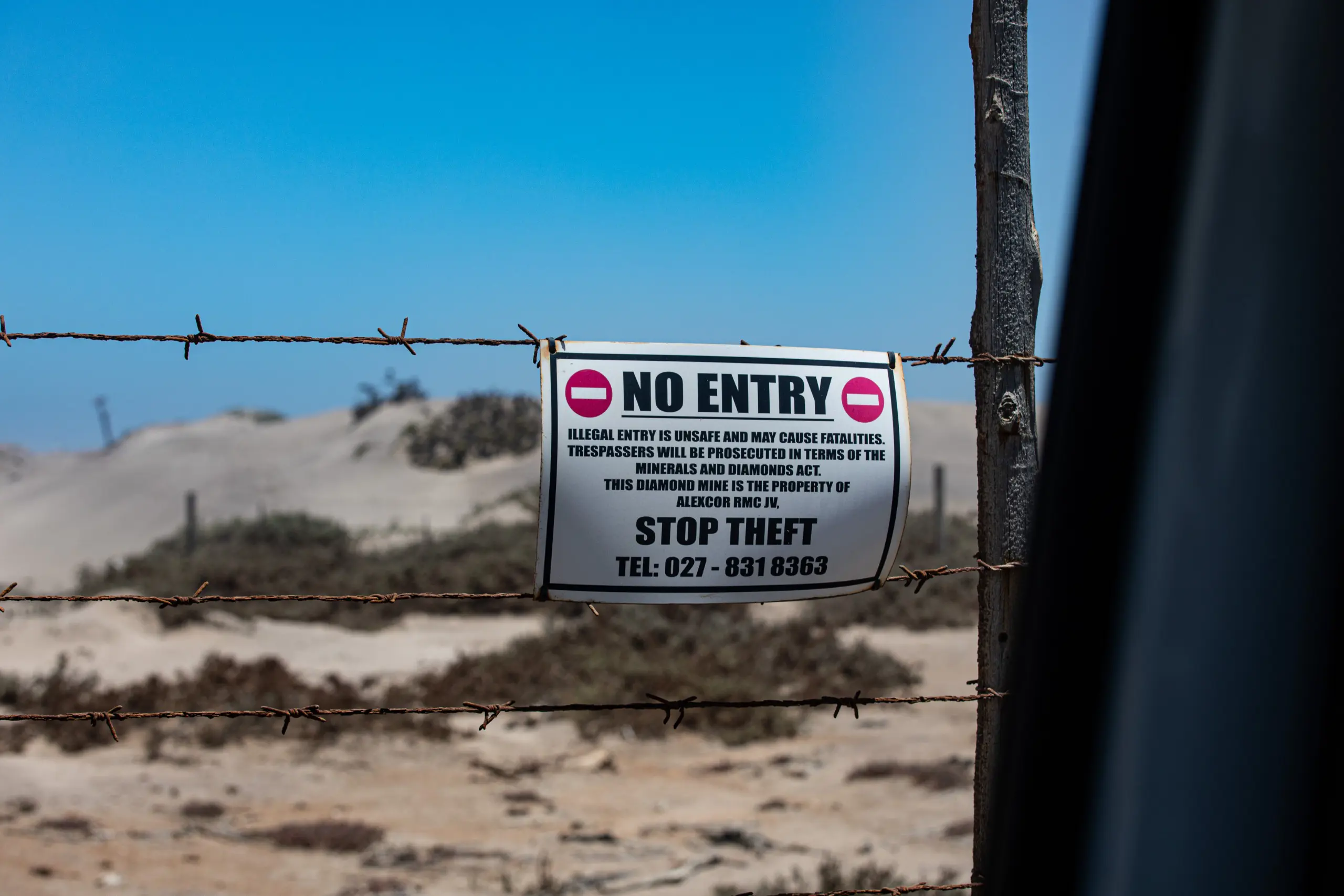 Several signs like this hang on barbed wire warning Zama Zamas not to trespass, however, illegal mining is still rife in mines across the Namaqualand. Picture: Kayleen Morgan/Eyewitness News Several signs like this hang on barbed wire warning Zama Zamas not to trespass, however, illegal mining is still rife in mines across the Namaqualand. Picture: Kayleen Morgan/Eyewitness News